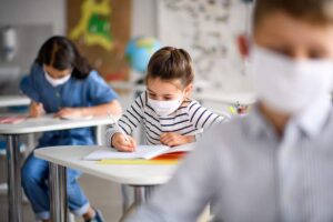 crianças na sala de aula de máscara